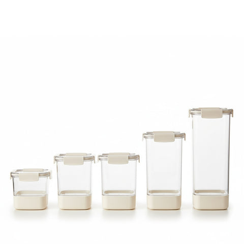 Set of clear glass containers with beige lids on a white background