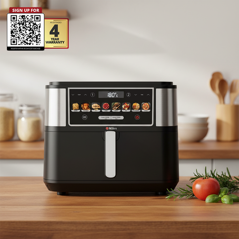 Black and silver air fryer on a wooden countertop with kitchen items in the background