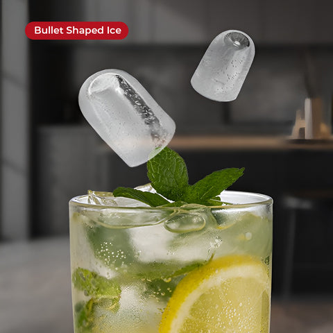 Glass of lemonade with mint leaves and bullet-shaped ice cubes against a blurred background