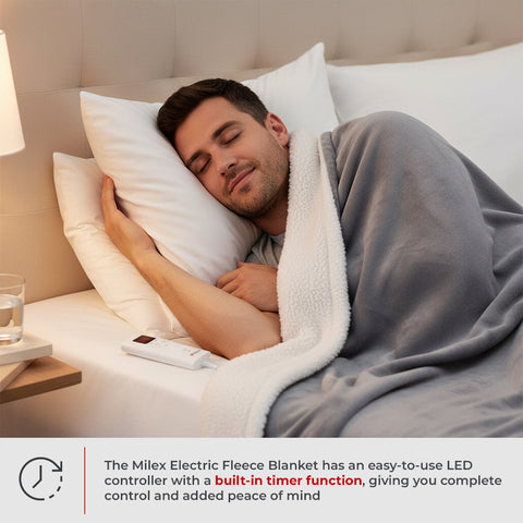 Man sleeping under a gray electric fleece blanket with a remote control on a nightstand.
