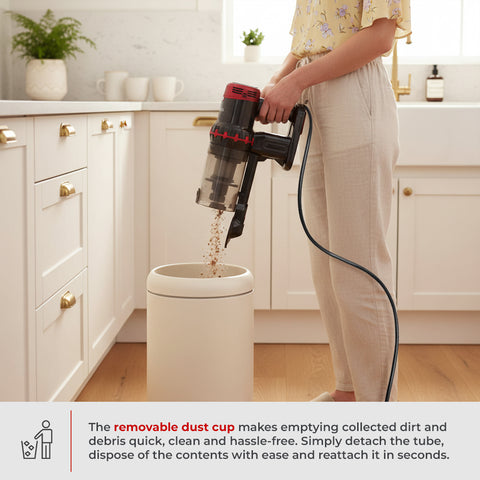A person in a kitchen uses a vacuum cleaner with a transparent dust cup to empty debris into a trash can. A text banner at the bottom explains the removable dust cup feature.