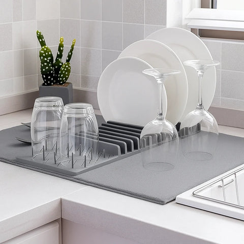 Dish rack with white plates and glasses on a kitchen counter.