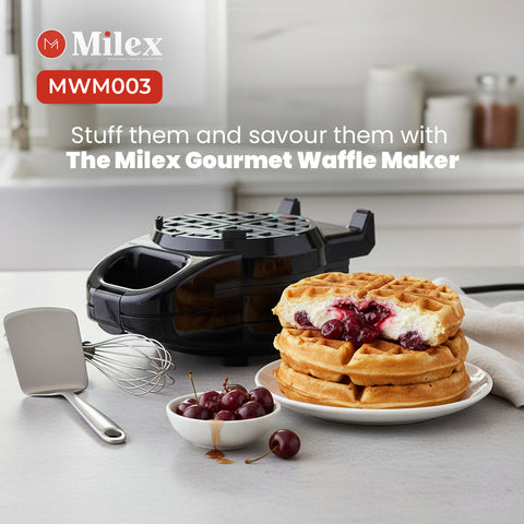 Milex gourmet waffle maker with waffles and cherries on a table