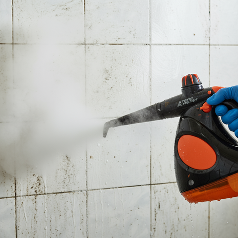 Person using a steam cleaner on a tiled wall